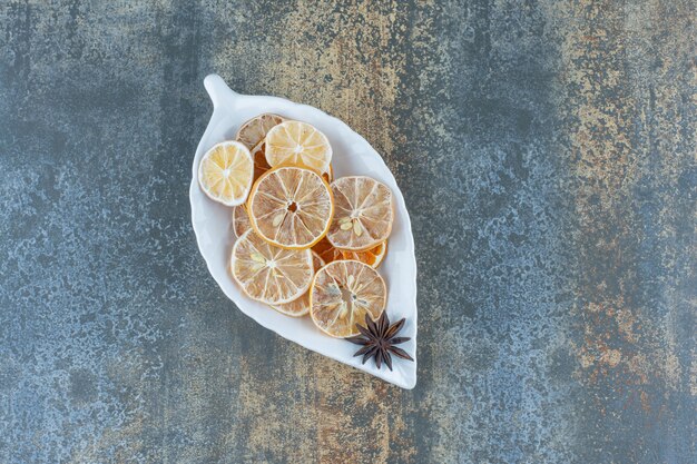 Dried lemon slices on leaf-shaped plate.