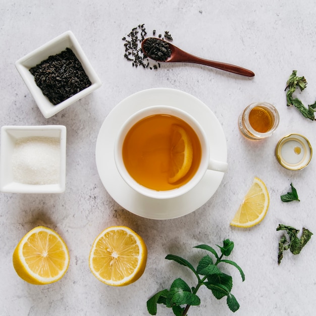 Бесплатное фото Лимонный чай сушеный с сахаром; мята и мед на бетонном фоне