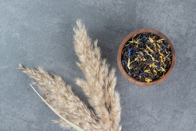 Dried loose teas with wheat on a wooden bowl