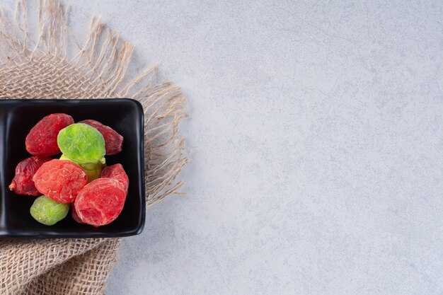 Dried multicolor fruit jellies isolated on concrete background.