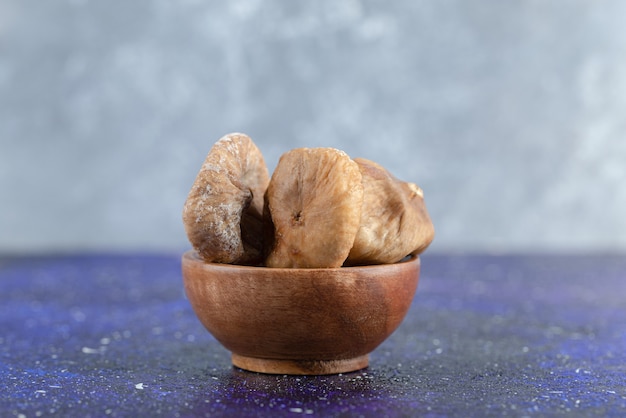 Dried natural figs in wooden bowl.