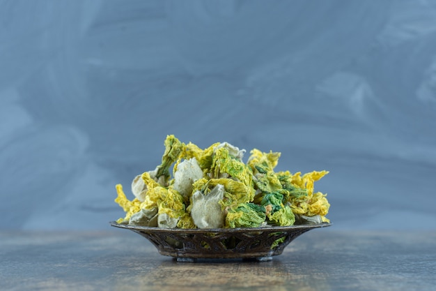 Free photo dried natural yellow flowers in metal bowl.