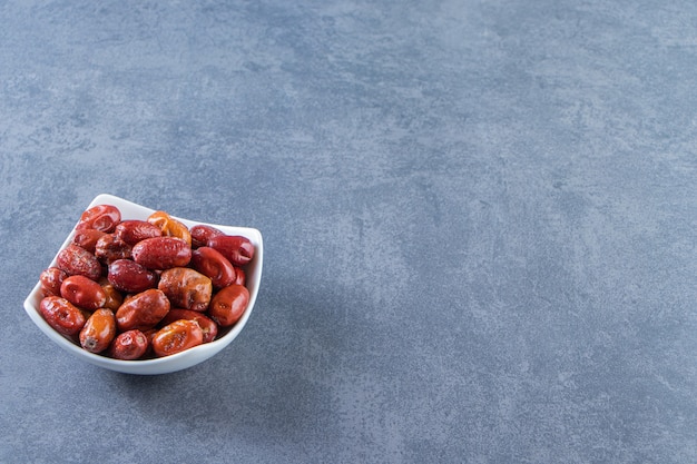 Dried oleaster in a bowl, on the marble background.