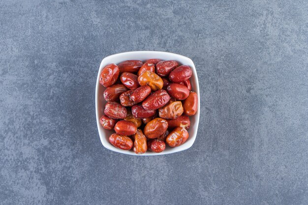 Dried oleaster in a bowl, on the marble background.