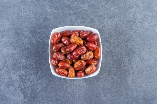 Dried oleaster in a bowl, on the marble background.