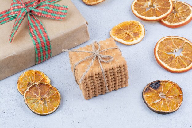 Dried orange, biscuits and gift box on marble background. 