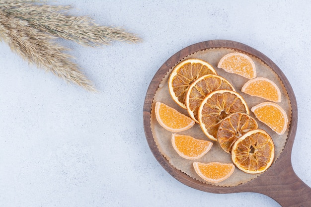 Dried orange slices and marmalades on wooden board. 