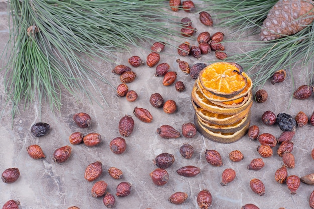 Dried orange slices with hips on marble.