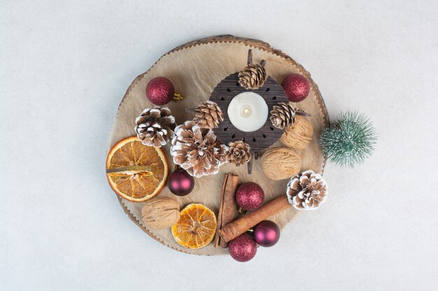 Dried orange with pinecones and Christmas balls on wooden plate. High quality photo