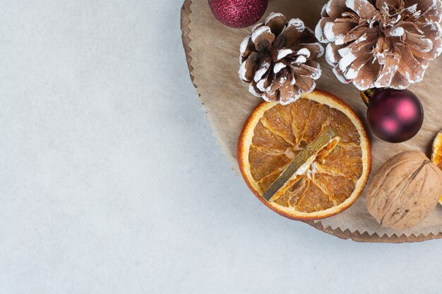 Dried orange with pinecones and Christmas balls on wooden plate. High quality photo