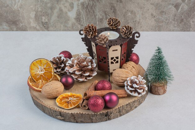木の板に松ぼっくりとクリスマスボールが付いた乾燥オレンジ。高品質の写真