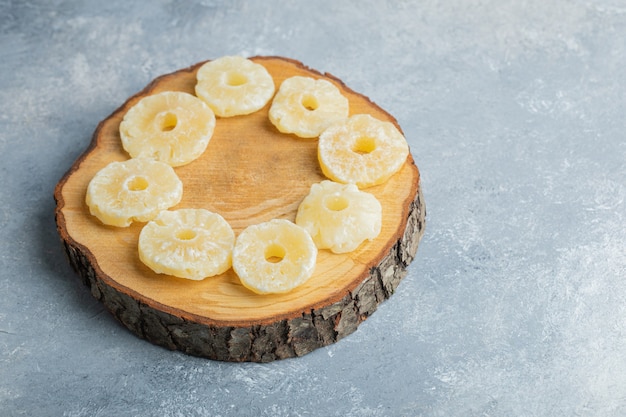 Dried organic pineapple rings placed on wood piece