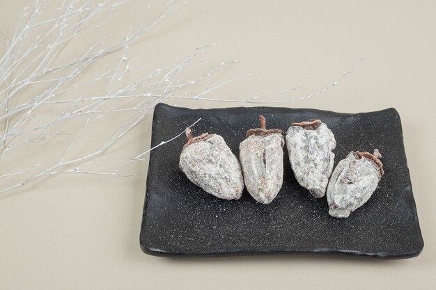 Dried persimmon fruits on black plate