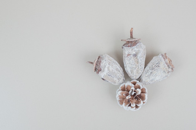 Dried persimmon and pinecone on beige surface