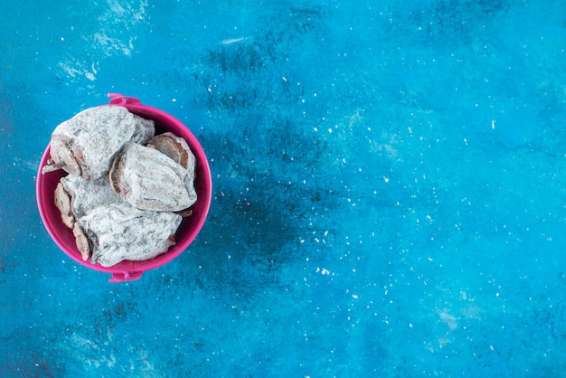 Dried persimmons in a bucket , on the blue table. 