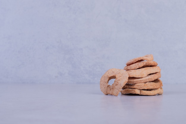 Dried pineapple rings on white surface.