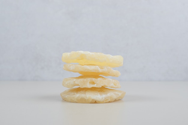 Dried pineapple slices on beige surface