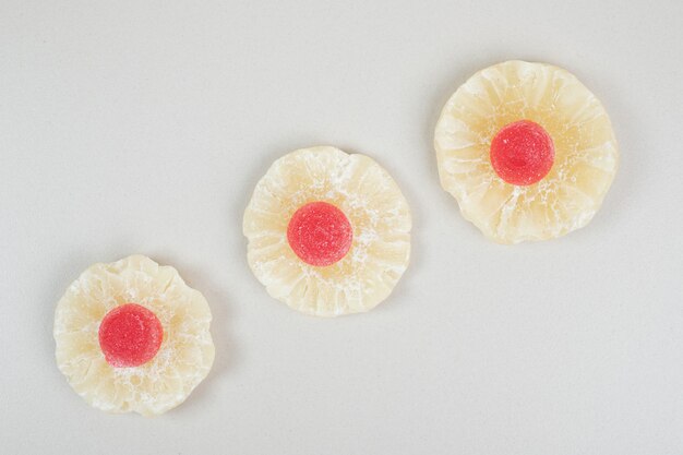 Dried pineapple slices and marmalades on beige surface