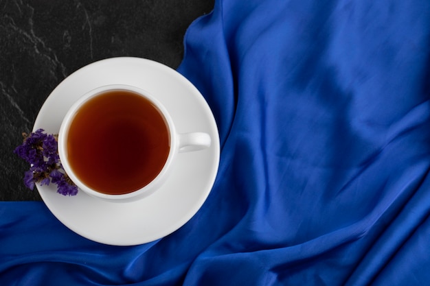 Free photo dried purple flowers with a cup of hot tea on a black table .