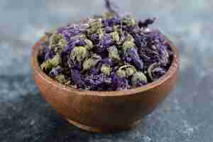 Free photo dried purple flowers in wooden bowl.