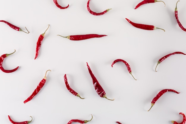 dried red chili pepper on white surface top view
