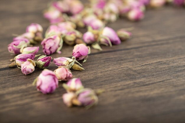 Dried rose flower buds placed on a wooden table 