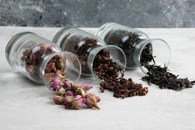 Dried roses with loose teas on gray.