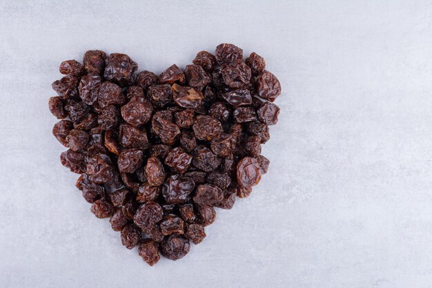 Dried sour black cherries isolated on concrete background. High quality photo