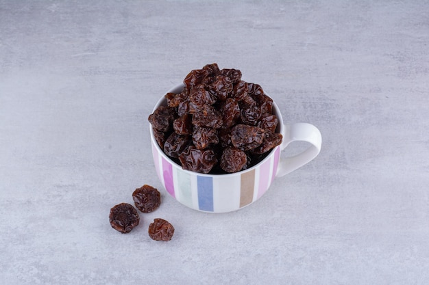 Dried sour cherries in a cup on concrete background. High quality photo