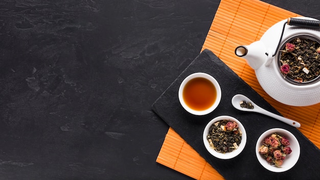 Dried tea herb and pink orchid flower and black textured backdrop