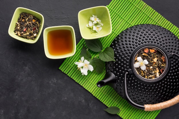 Dried tea herb with white jasmine flower on textured background