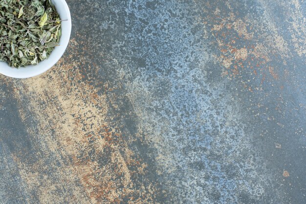 Dried tea leaves in white bowl.