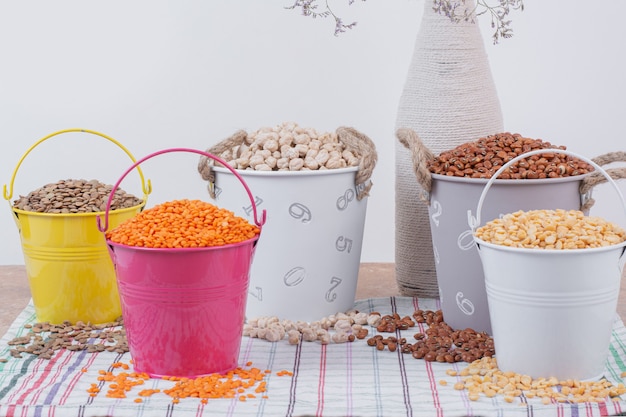 Dried various beans in colorful buckets.