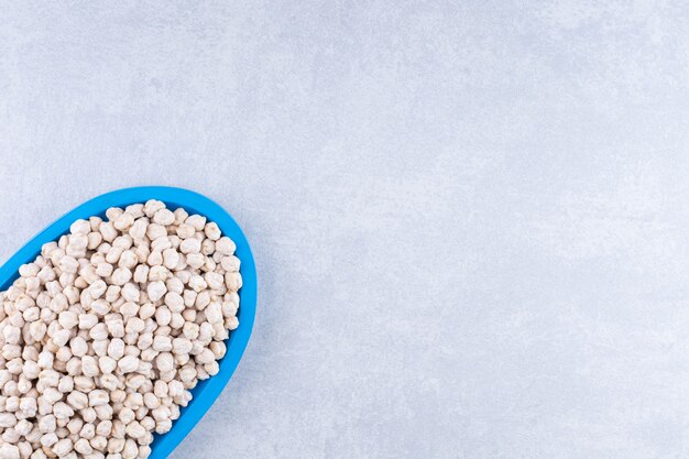 Dried and washed platter of chickpeas on marble surface