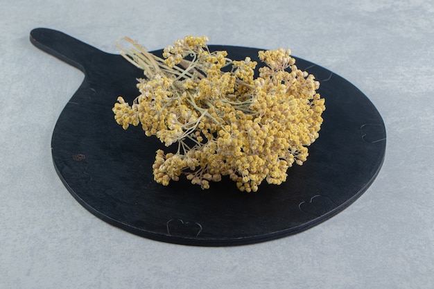 Dried yellow flowers on black board.  