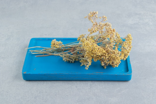 Free photo dried yellow flowers on blue board