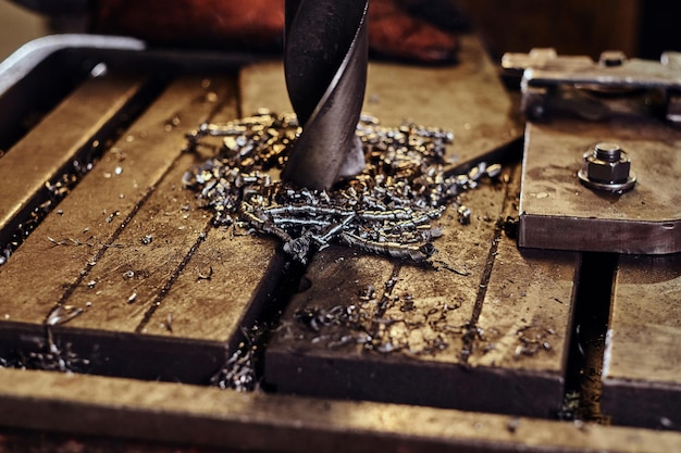 労働者の男性による鉄鋼工場での巨大なドリルで金属に穴を開ける。