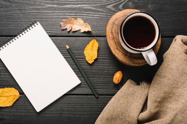 Drink and cloth near leaves and stationery