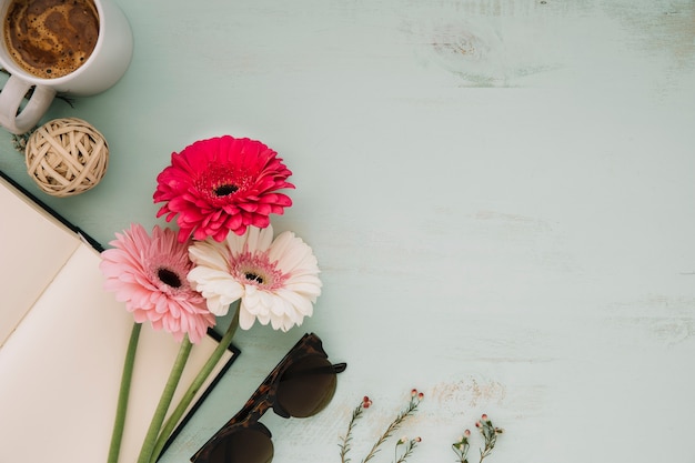 Foto gratuita bevi vicino a fiori e quaderni