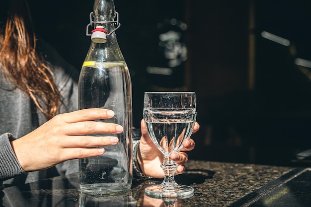 Bottola d'acqua da bere con bicchiere sul tavolo nel ristorante