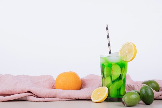 Drink with apple, feijoa and straw on white