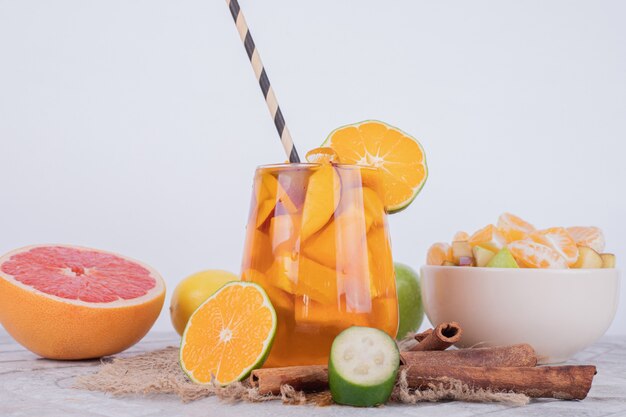 Drink with grapefruit, lime and cinnamon on white .