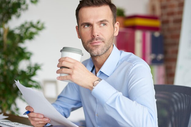 コーヒーを飲み、書類から目をそらす