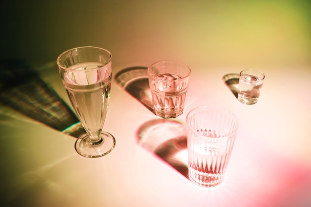 Бесплатное фото Напитки в разных типах стаканов с тенью на цветном фоне