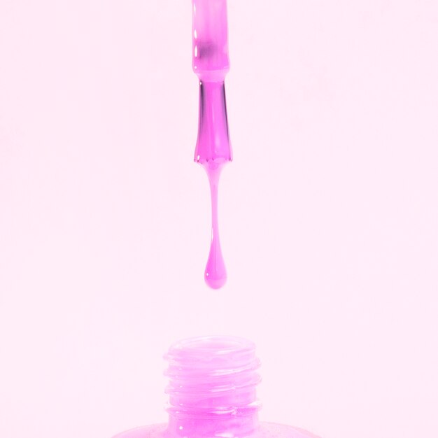 물이 뚝뚝 떨어지는 핑크 컬러 매니큐어 흰색 배경에 고립