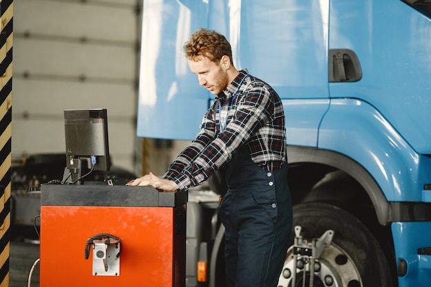 Free photo driver checks the goods. man in uniform. truck in the garage