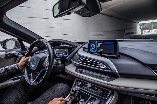 A driver driving a car, interior view.