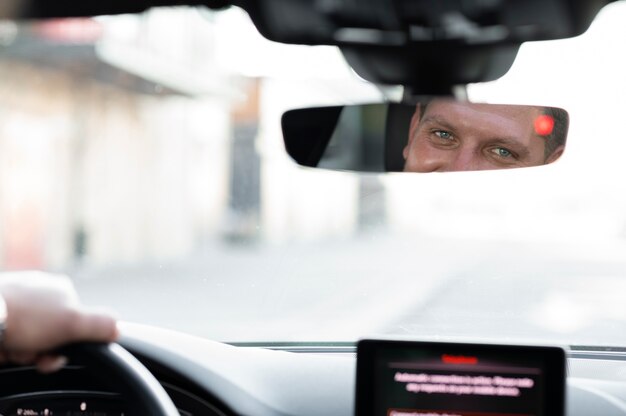 Водитель смотрит в зеркало автомобиля