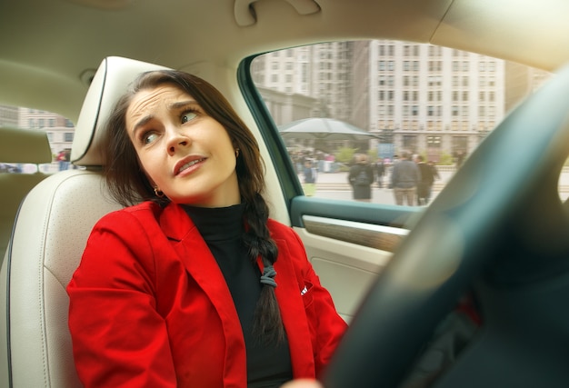 Guidare in città. giovane donna attraente alla guida di un'auto.