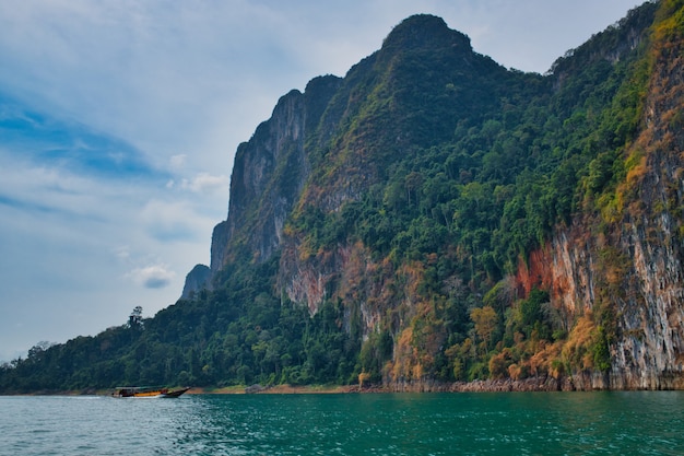 Вождение длиннохвостой лодки на озере Као Сок в Таиланде среди красивых скалистых пейзажей